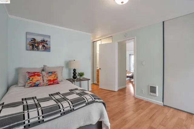a bedroom with two beds and wooden floor