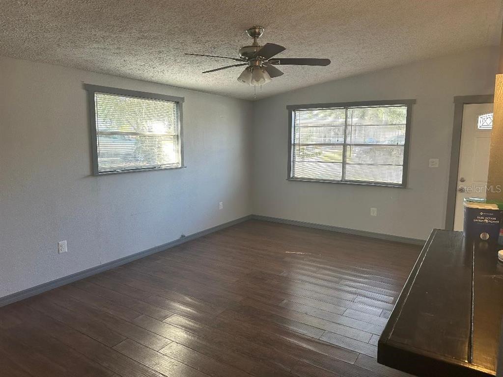4048 Pecos Drive New Port Richey, FL 34653 - Photo 4 of 15 an empty room with wooden floor and windows