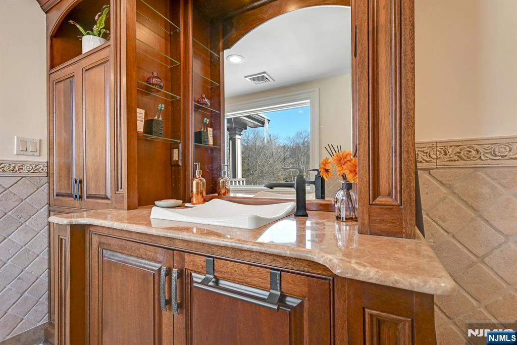 285 Chestnut Ridge Road Woodcliff Lake, NJ 07677 - Photo 42 of 46 a bathroom with a granite countertop sink and a mirror