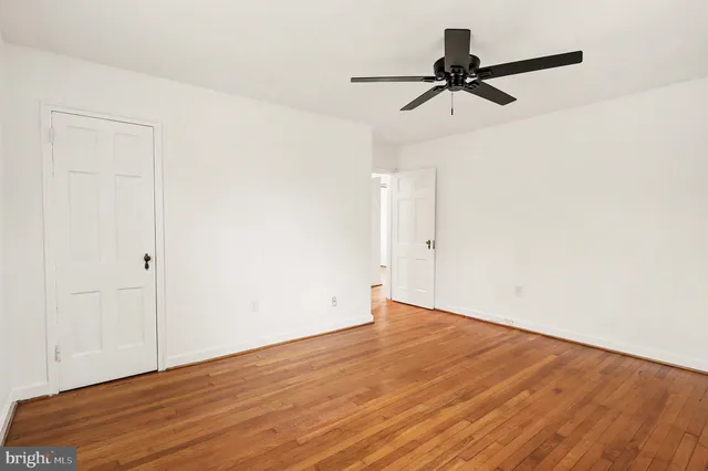 a view of a room with wooden floor and a ceiling fan