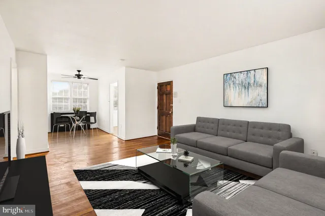 a living room with furniture a dining table and a chandelier