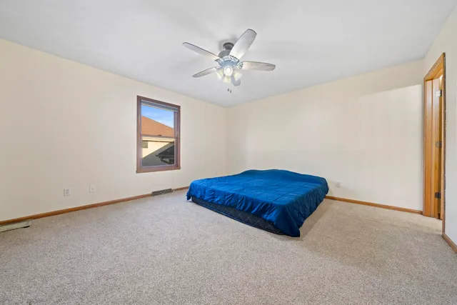 a view of empty room with window and ceiling fan