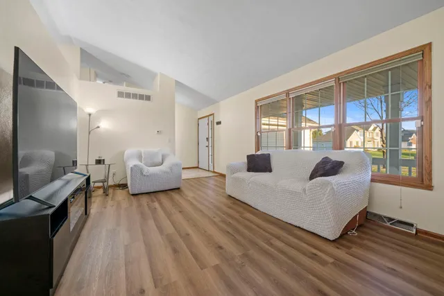 a living room with furniture a flat screen tv and a large window