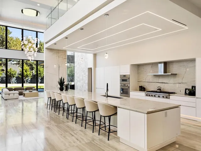 a kitchen with stainless steel appliances kitchen island granite countertop a stove a sink and a refrigerator