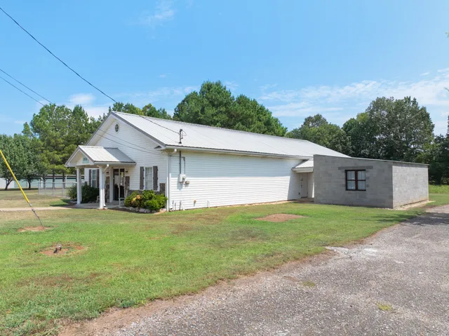 a room with furniture a chandelier fan and a window