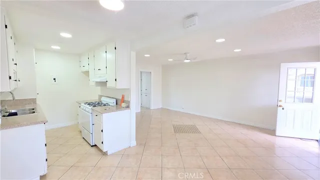 a view of kitchen with cabinets and window