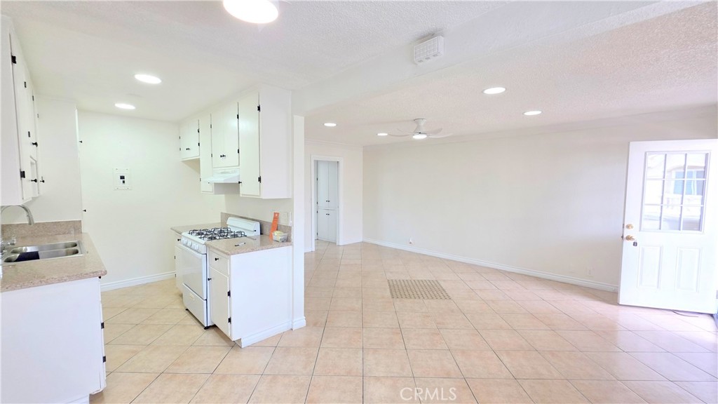 a view of kitchen with cabinets and window