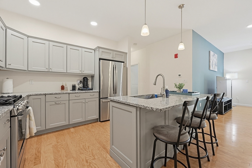 200 Revere Street, Unit 4209 Canton, MA 02021 - Photo 13 of 35 a kitchen with a sink a refrigerator and chairs