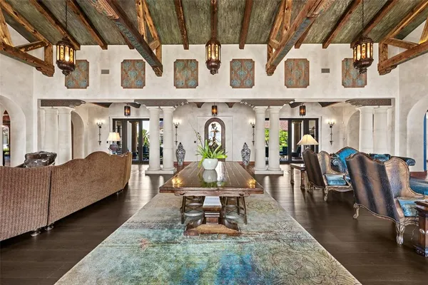 a living room with patio furniture and a chandelier