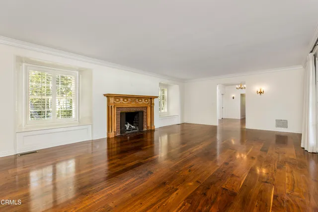 a view of empty room with wooden floor and fireplace