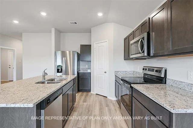 a kitchen with stainless steel appliances granite countertop a sink stove and refrigerator