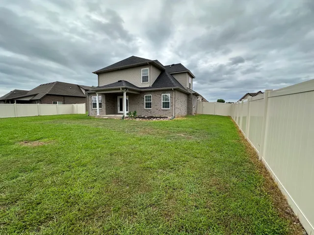 a view of a big house with a big yard and large trees