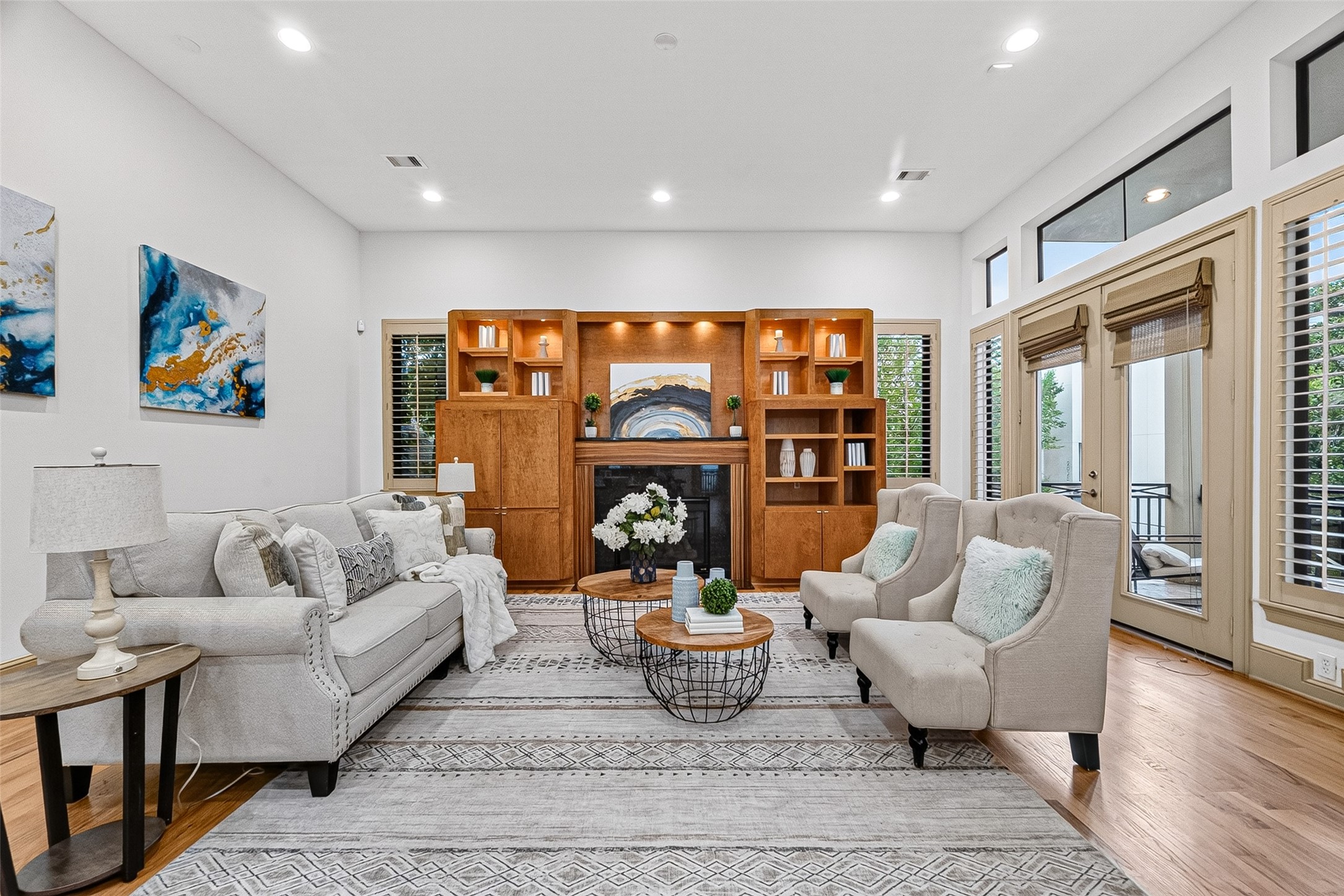 2034 Colquitt Street, Unit A Houston, TX 77098 - Photo 18 of 41 This spacious living room features a cozy fireplace, elegant built-in shelves, large windows for natural light, and French Doors leading to the second floor balcony.