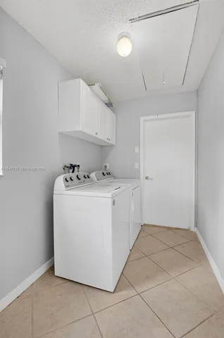 a utility room with cabinets washer and dryer