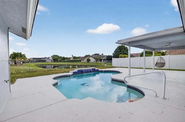 a swimming pool with outdoor seating and garden