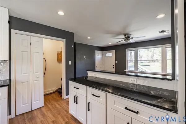 a spacious bathroom with a granite countertop sink a mirror and a shower