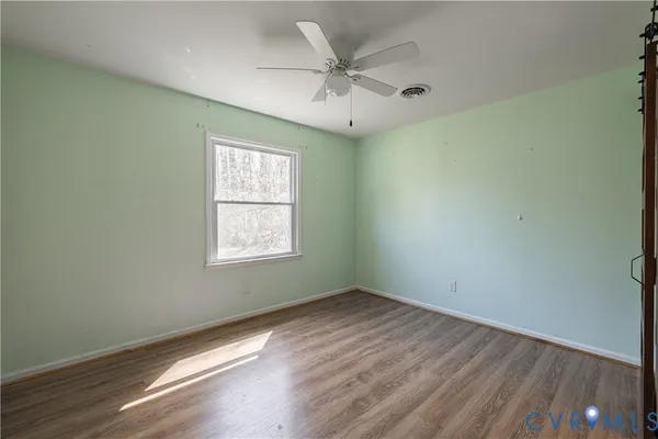 wooden floor in an empty room with a window