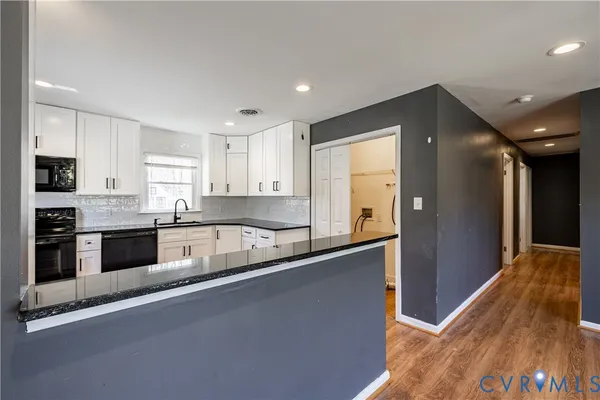 a large kitchen with granite countertop a stove and a refrigerator