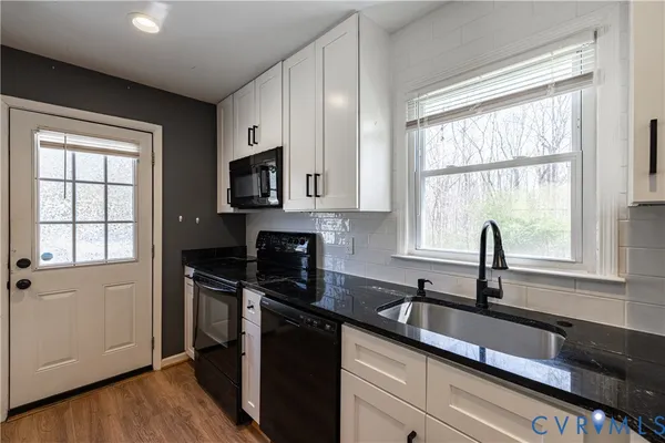 a kitchen with granite countertop a sink and a stove top oven