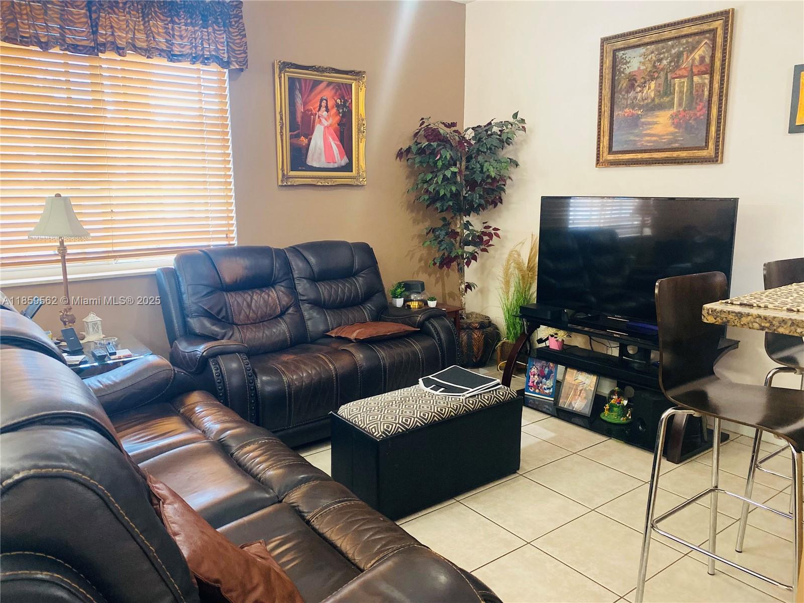 7760 Northwest 163rd Street Miami Lakes, FL 33016 - Photo 17 of 68 a living room with furniture a flat screen tv and a potted plant