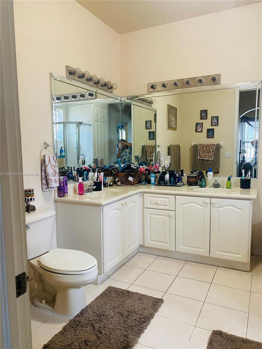7760 Northwest 163rd Street Miami Lakes, FL 33016 - Photo 42 of 68 a bathroom with a sink a toilet and mirror