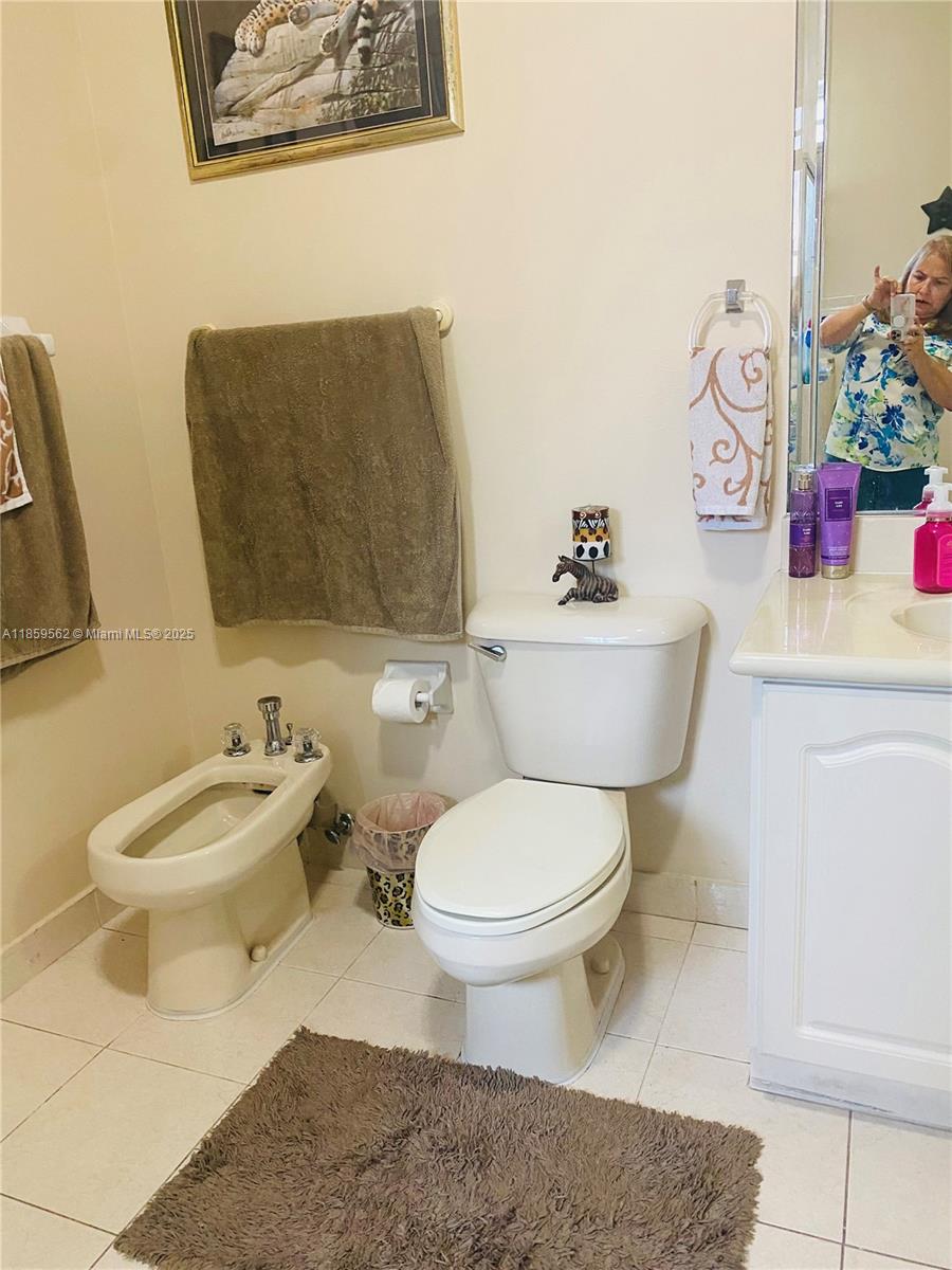7760 Northwest 163rd Street Miami Lakes, FL 33016 - Photo 43 of 68 a white toilet sitting next to a bathroom sink