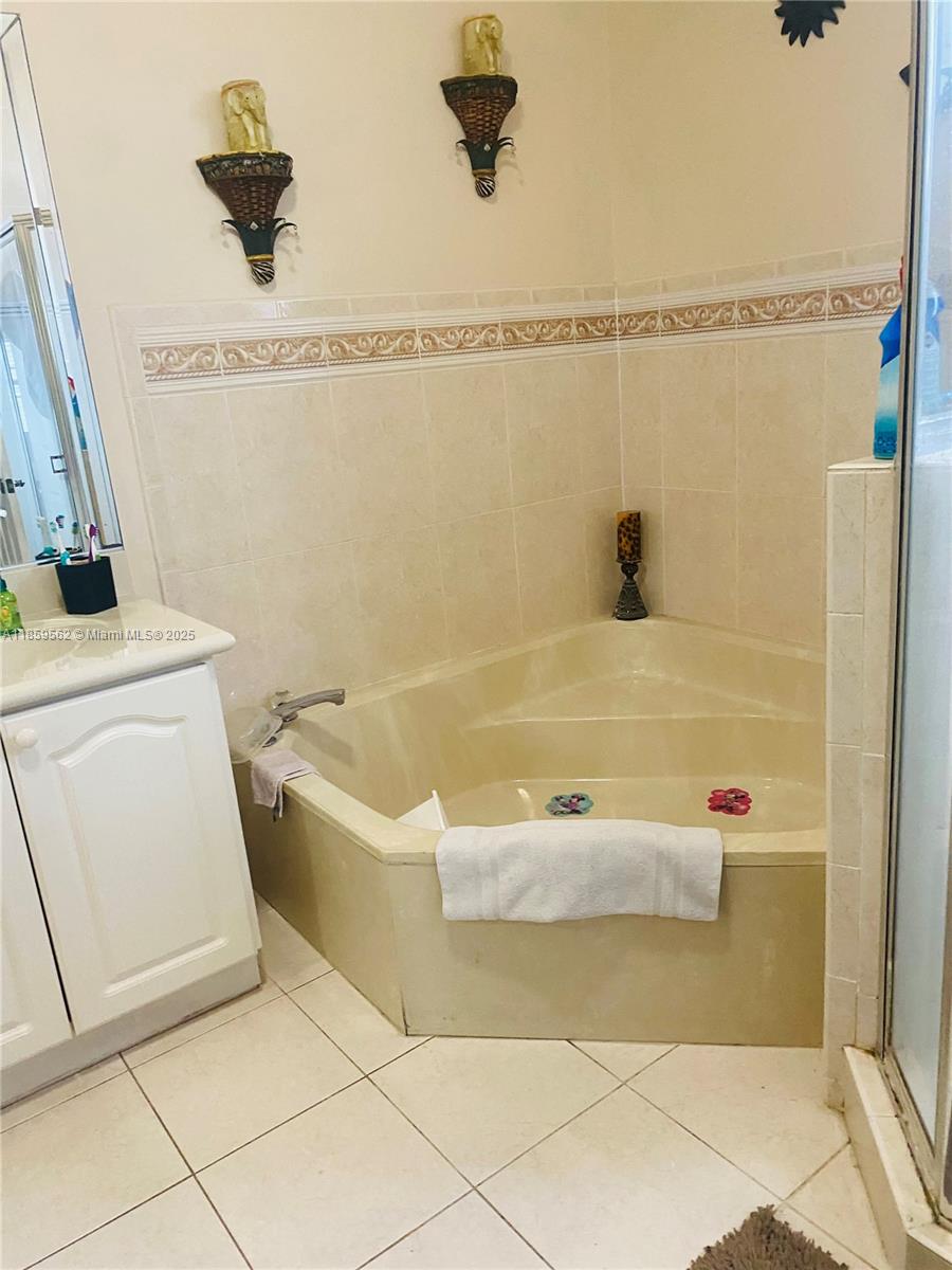 7760 Northwest 163rd Street Miami Lakes, FL 33016 - Photo 44 of 68 a bathroom with a bathtub and a shower