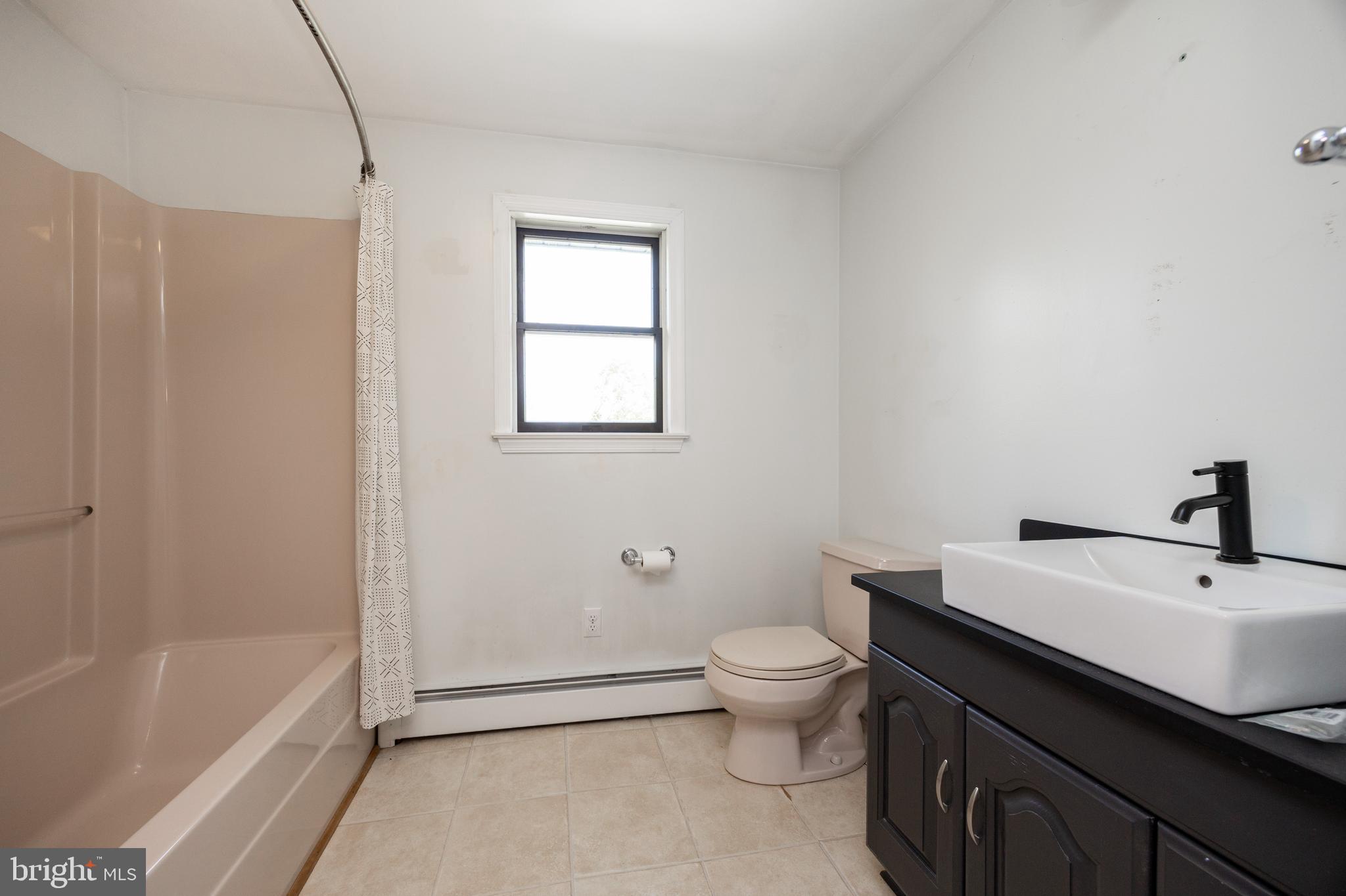 5509 Hoppenville Road Green Lane, PA 18054 - Photo 42 of 70 a bathroom with a sink a toilet and bathtub