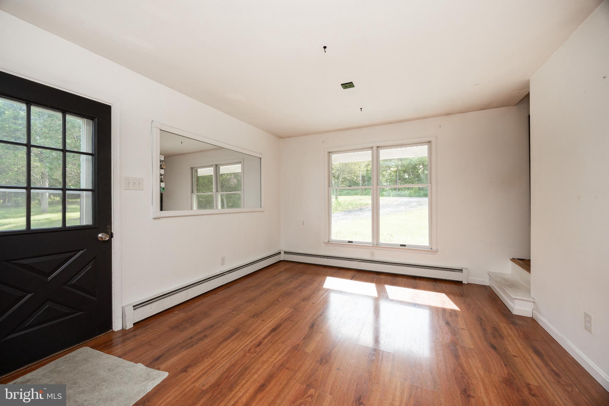 5509 Hoppenville Road Green Lane, PA 18054 - Photo 7 of 70 an empty room with wooden floor and windows