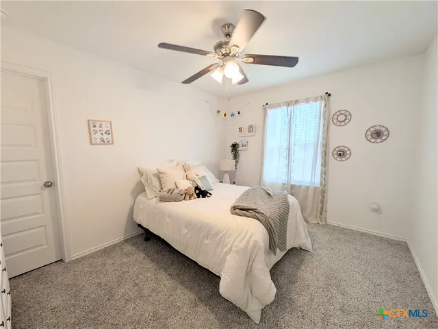 a bedroom with a bed and a ceiling fan
