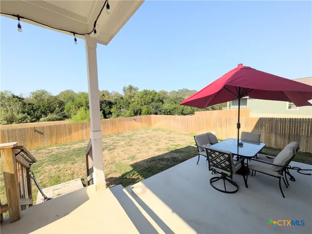a view of an outdoor sitting area with furniture and umbrella