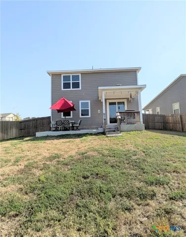 a view of a house with backyard and a garden