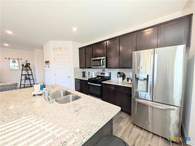 a kitchen with granite countertop a refrigerator and a sink
