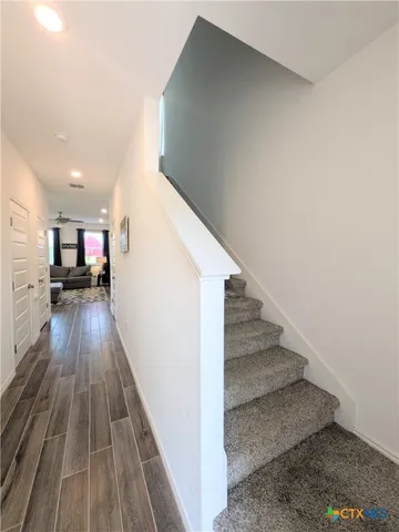 a view of entryway and kitchen with wooden floor