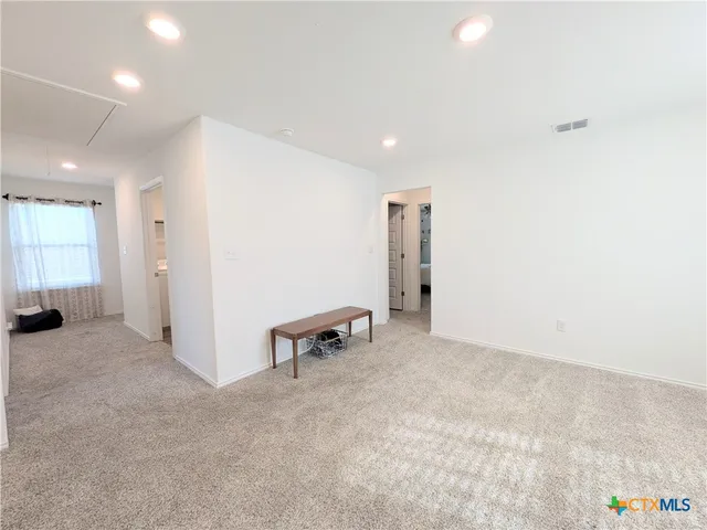 an empty room with windows and furniture