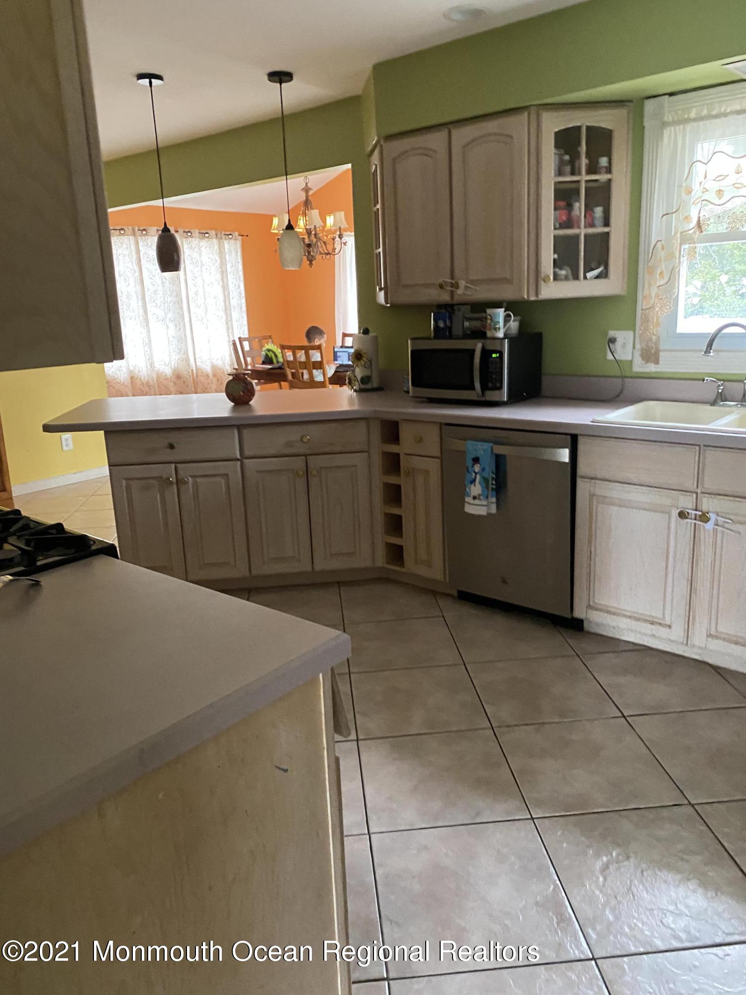 155 Port Road Brick, NJ 08723 - Photo 2 of 4 a kitchen with a sink a counter top space cabinets and stainless steel appliances