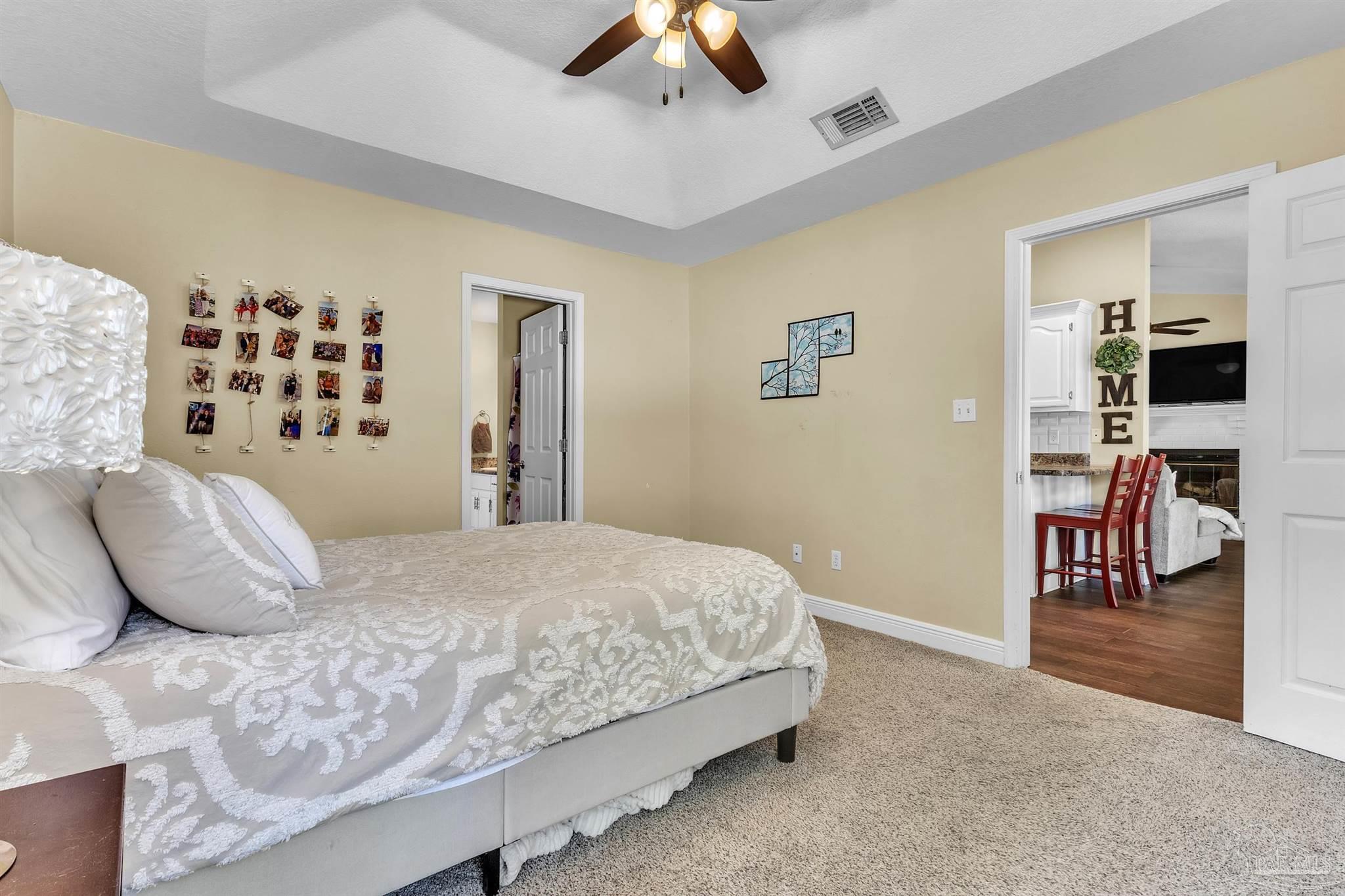4321 Ridgeland Drive Pace, FL 32571 - Photo 15 of 36 a bedroom with a large bed and a chandelier