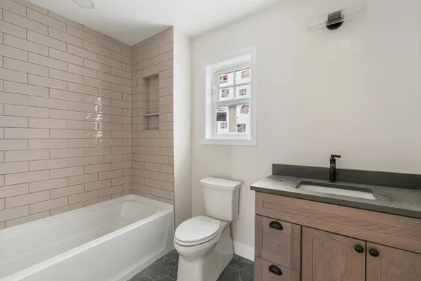 a bath room with a toilet a sink and a bath tub