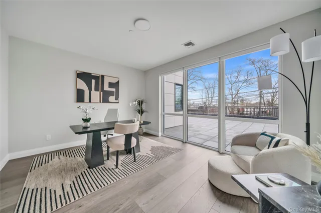a living room with furniture a large window and wooden floor