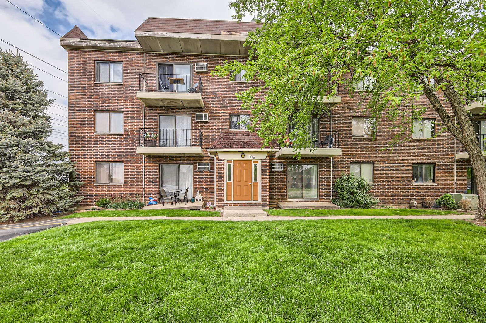 953 North Rohlwing Road, Unit 201A Addison, IL 60101 - Photo 1 of 11 a front view of a building with a yard table and chairs