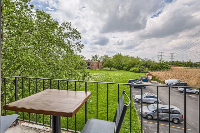 a view of a roof deck with chair and wooden floor