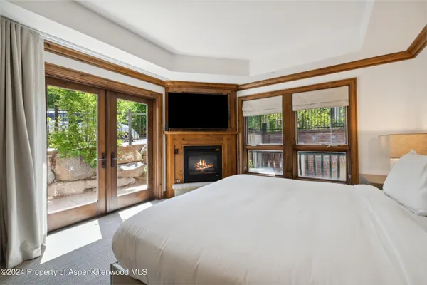 a large bedroom with windows and a fireplace