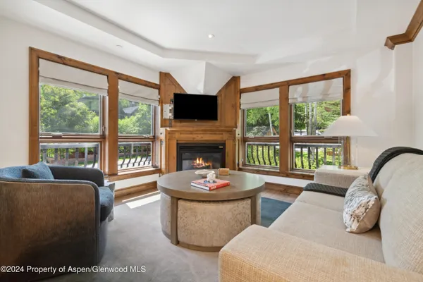 a living room with fireplace furniture and a large window
