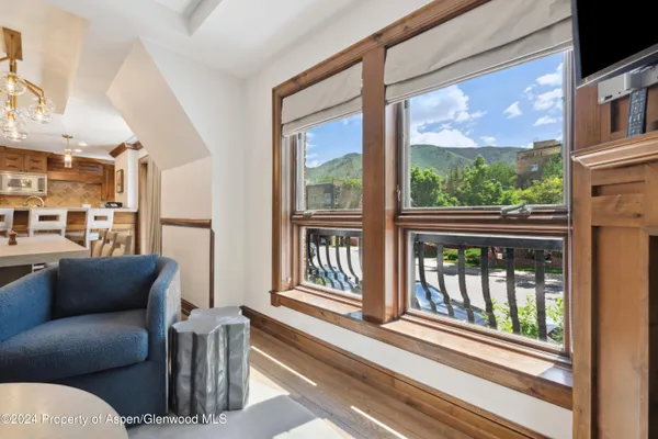 a living room with furniture a floor to ceiling window and floor to ceiling windows