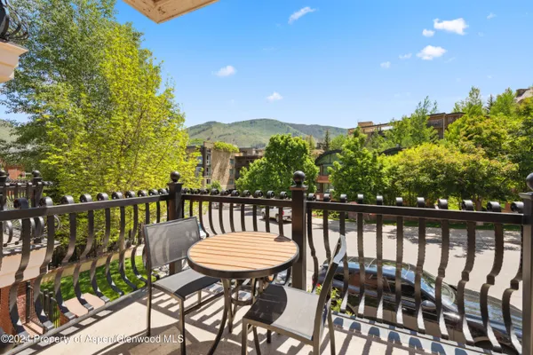 a view of a balcony with a table and chairs with wooden floor and fence