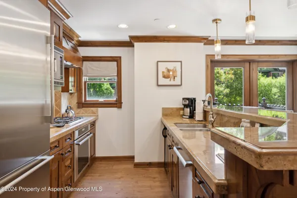 a kitchen with stainless steel appliances granite countertop a stove a sink and a refrigerator