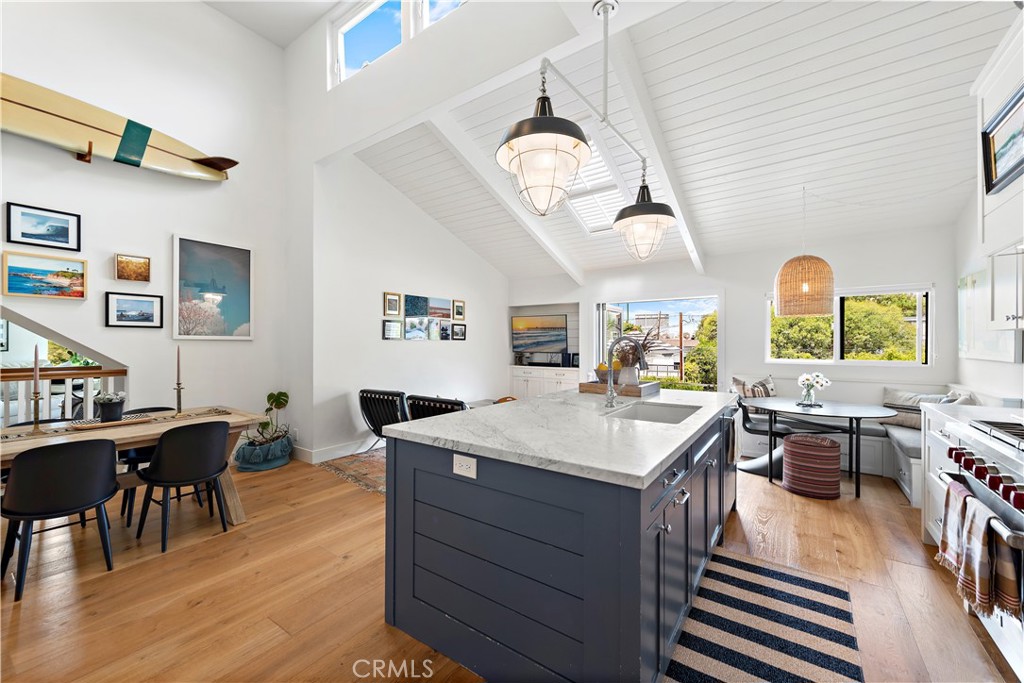 721 Browncroft Road Laguna Beach, CA 92651 - Photo 18 of 42 a living room with stainless steel appliances kitchen island a table chairs in it and wooden floors