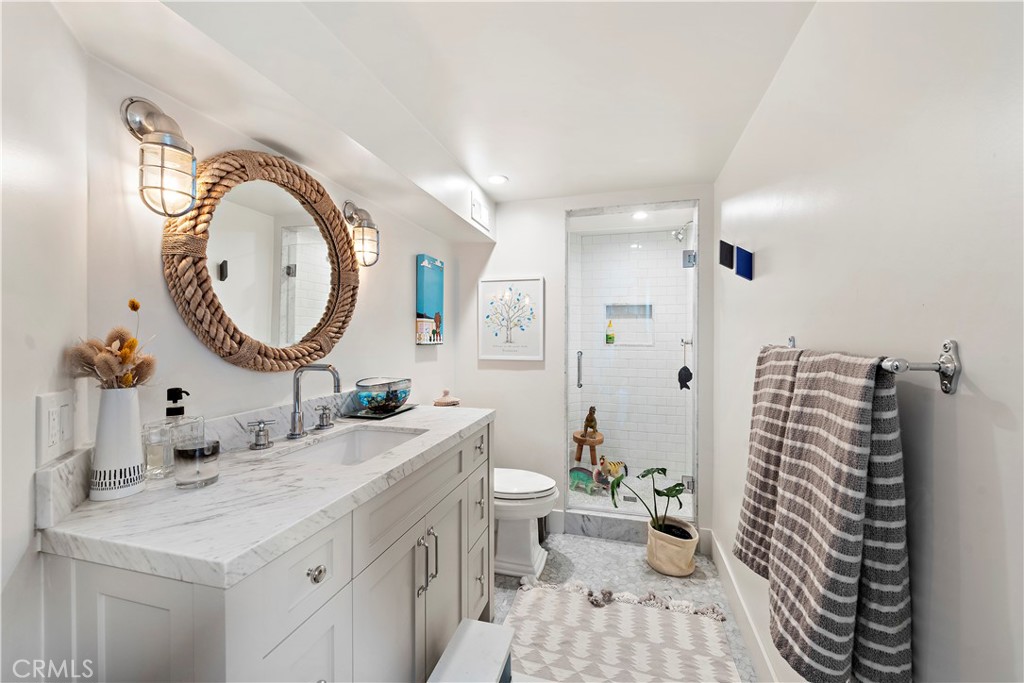 721 Browncroft Road Laguna Beach, CA 92651 - Photo 28 of 42 a bathroom with a sink a toilet and a mirror