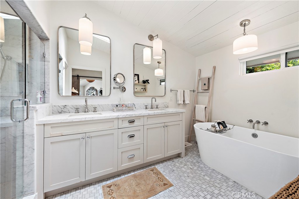 721 Browncroft Road Laguna Beach, CA 92651 - Photo 35 of 42 a bathroom with a double vanity sink a mirror and a bathtub