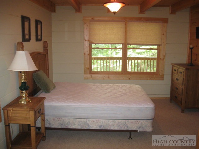 692 Mt Paron Road Deep Gap, NC 28618 - Photo 5 of 10 a bedroom with a bed flat screen tv and a large window